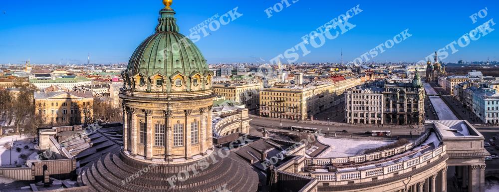 Фотография Казанского собора в Санкт-Петербурге с акцентом на его величественный купол и архитектурные детали. Снимок демонстрирует уникальную архитектуру исторического центра Петербурга, характерную для классического стиля российских городов. Купол собора, изящные колоннады и фасады создают гармоничный городской пейзаж, который привлекает внимание туристов и ценителей архитектуры. Панорамный и центрический ракурс позволяет увидеть масштабы сооружения и его окружение, включая улицы и площади города. Изображение идеально подходит для туристических публикаций, архитектурных проектов, постеров, сувенирной продукции и коллекций фотографий Санкт-Петербурга. Вид с дрона.